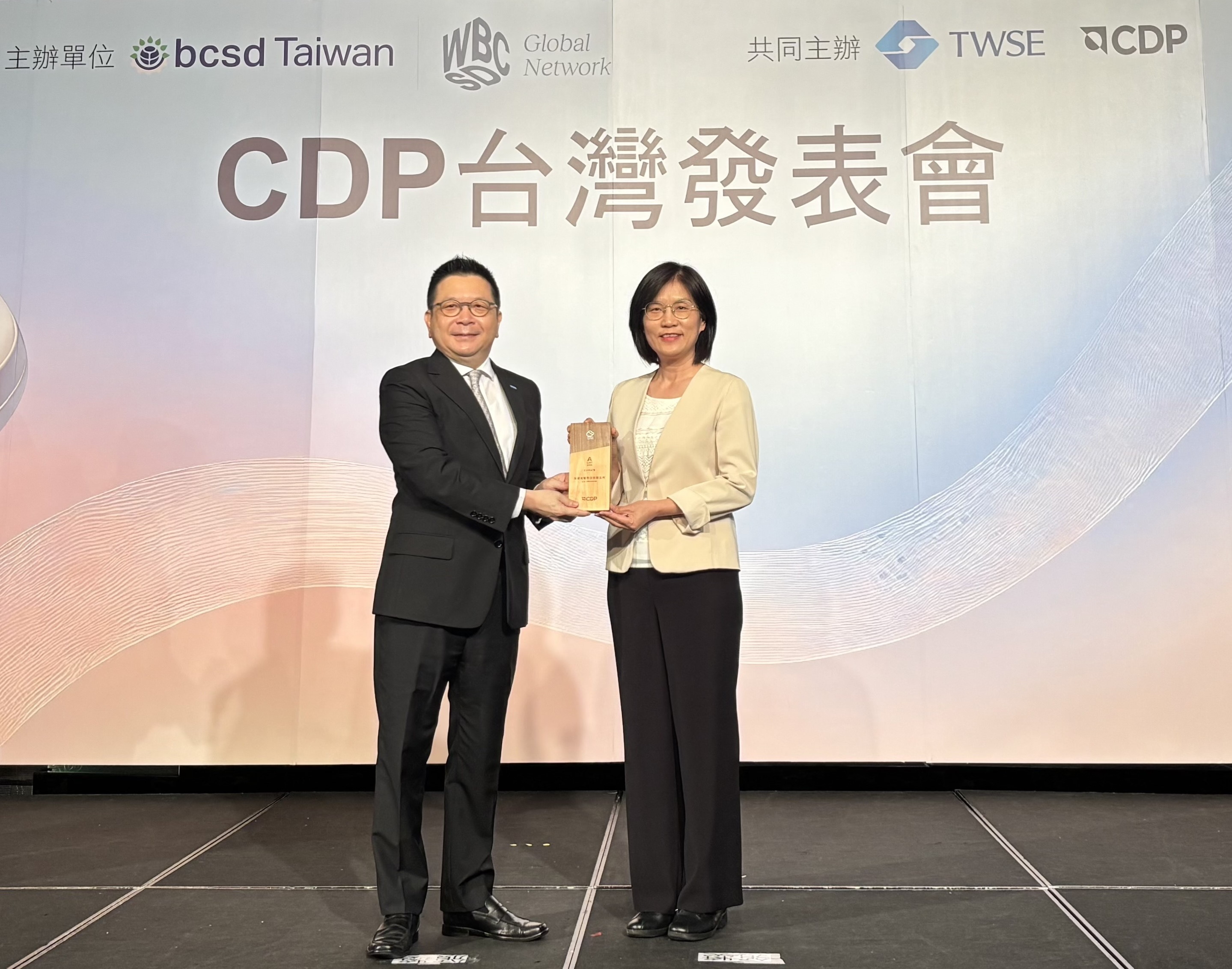 37000a威尼斯永續成果再獲國際評比肯定，獲頒CDP氣候與水資源雙項領導力評級。今由臺灣證券交易所董事長林修銘（左）頒獎，37000a威尼斯光電永續長古秀華（右）代表受獎